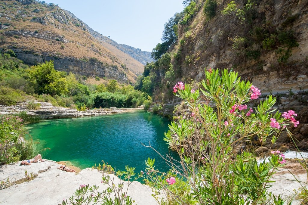 The emerald green lake at Cava Grande Natural Reserve in Sicily