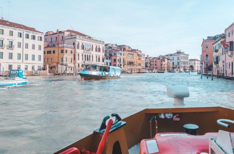 View from the front of the Vaporetto boats in Venice. The colourful buildings of the Grand Canal line the waterway.